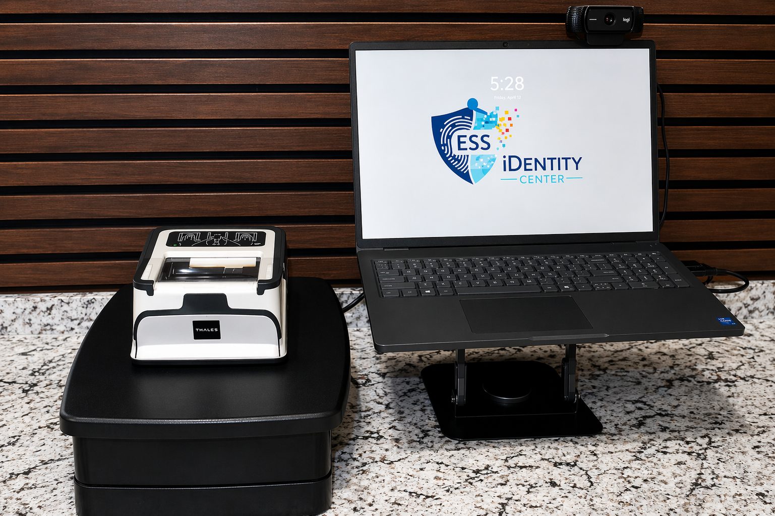 Laptop displaying ESS Identity logo next to two card printers on a table.